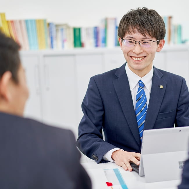 笑顔で接客するスーツの男性