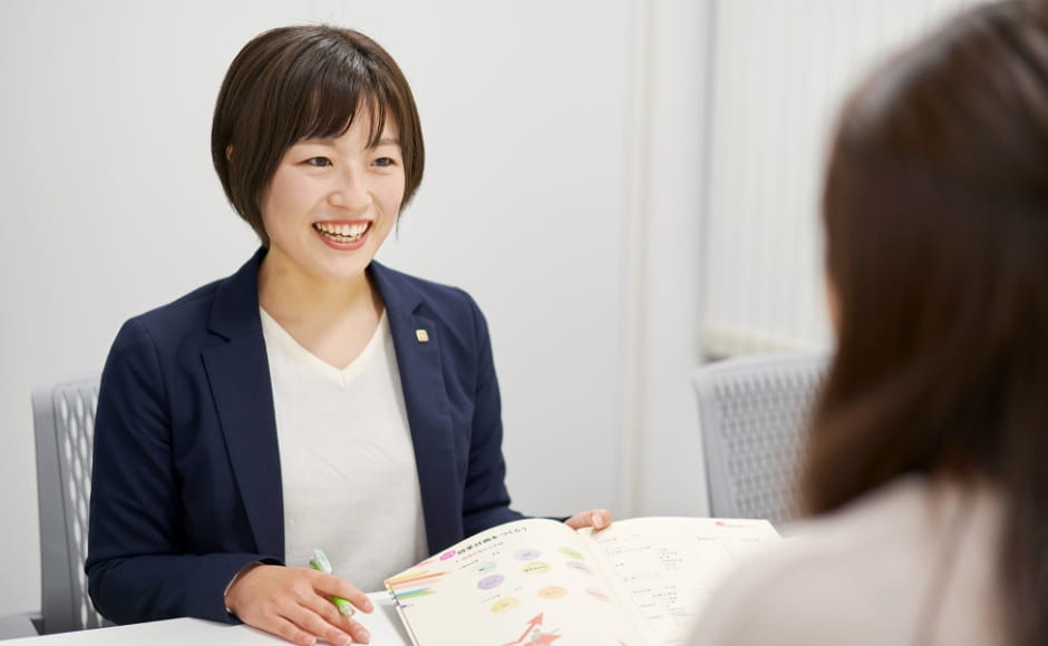 笑顔で接客するスーツの女性